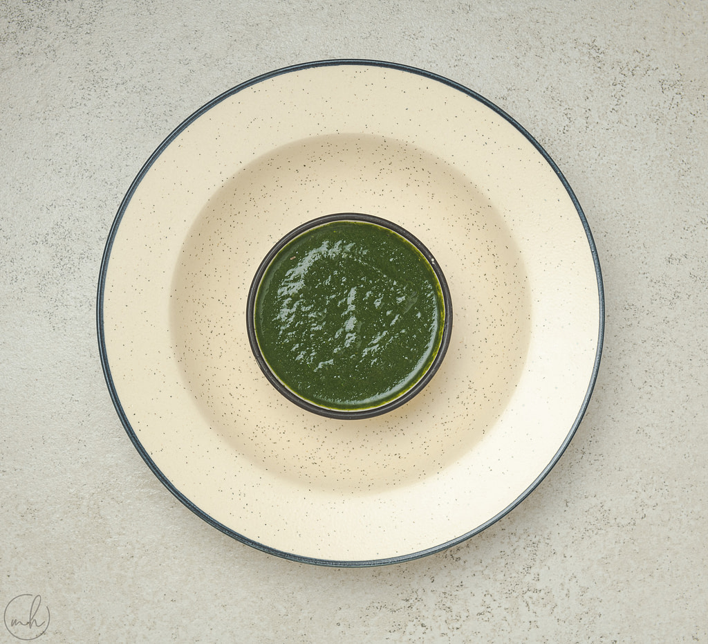 coriander & mint chutney placed in a bowl on a white plate