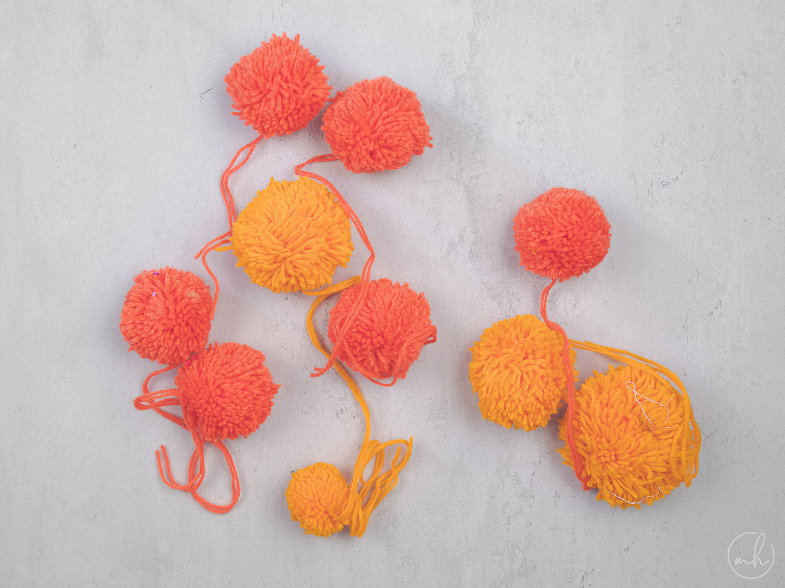 Red-yellow yarn pompoms with extra thread strewn around