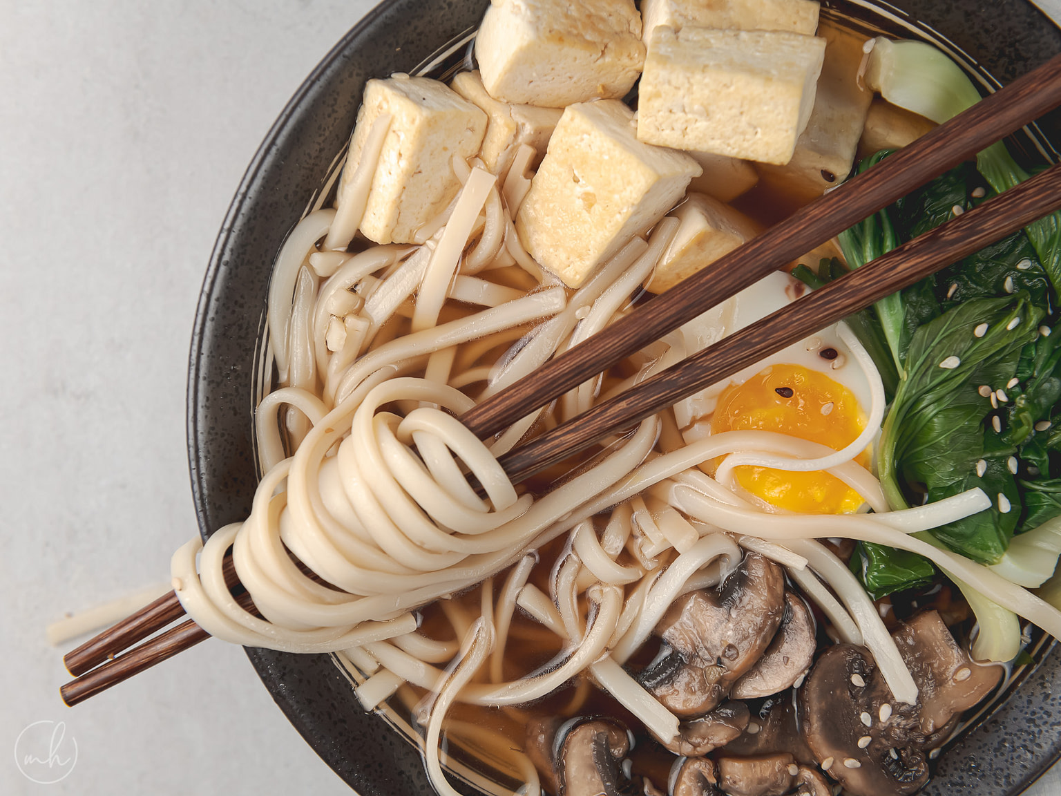 A bowl of miso and udon noodle soup.