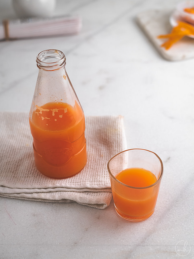 ginger & carrot booster juice placed in bottle over a white napkin
