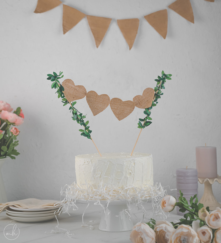 Burlap fern cake topper on white cake burlap party banner flowers plates napkin and candles behind