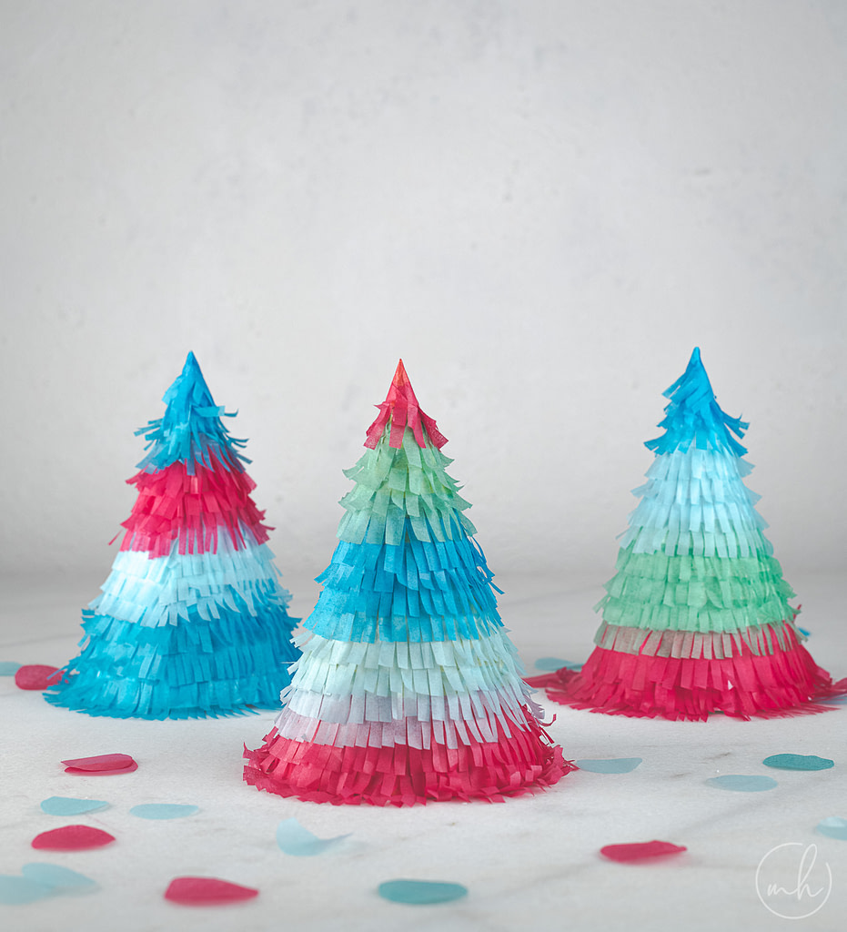 Colourful tissue fringe party hats with scattered confetti.