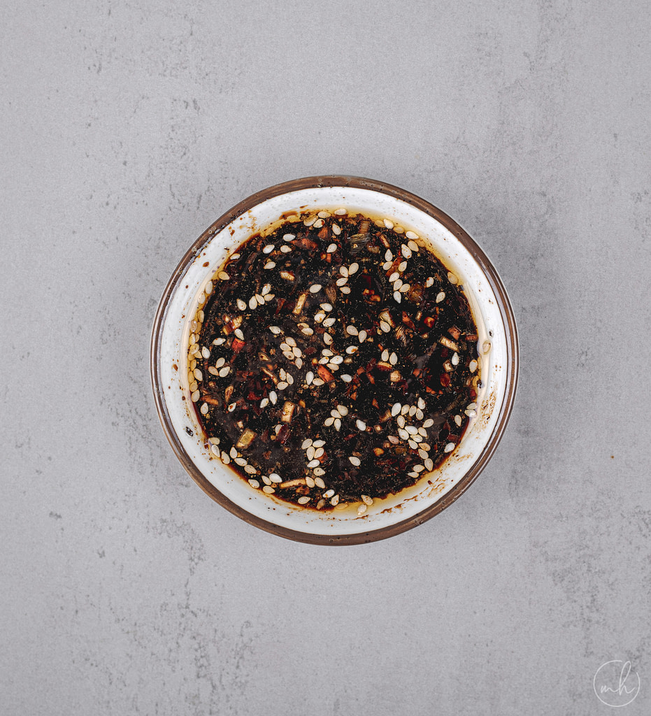 honey soy dipping sauce in a bowl over a grey surface