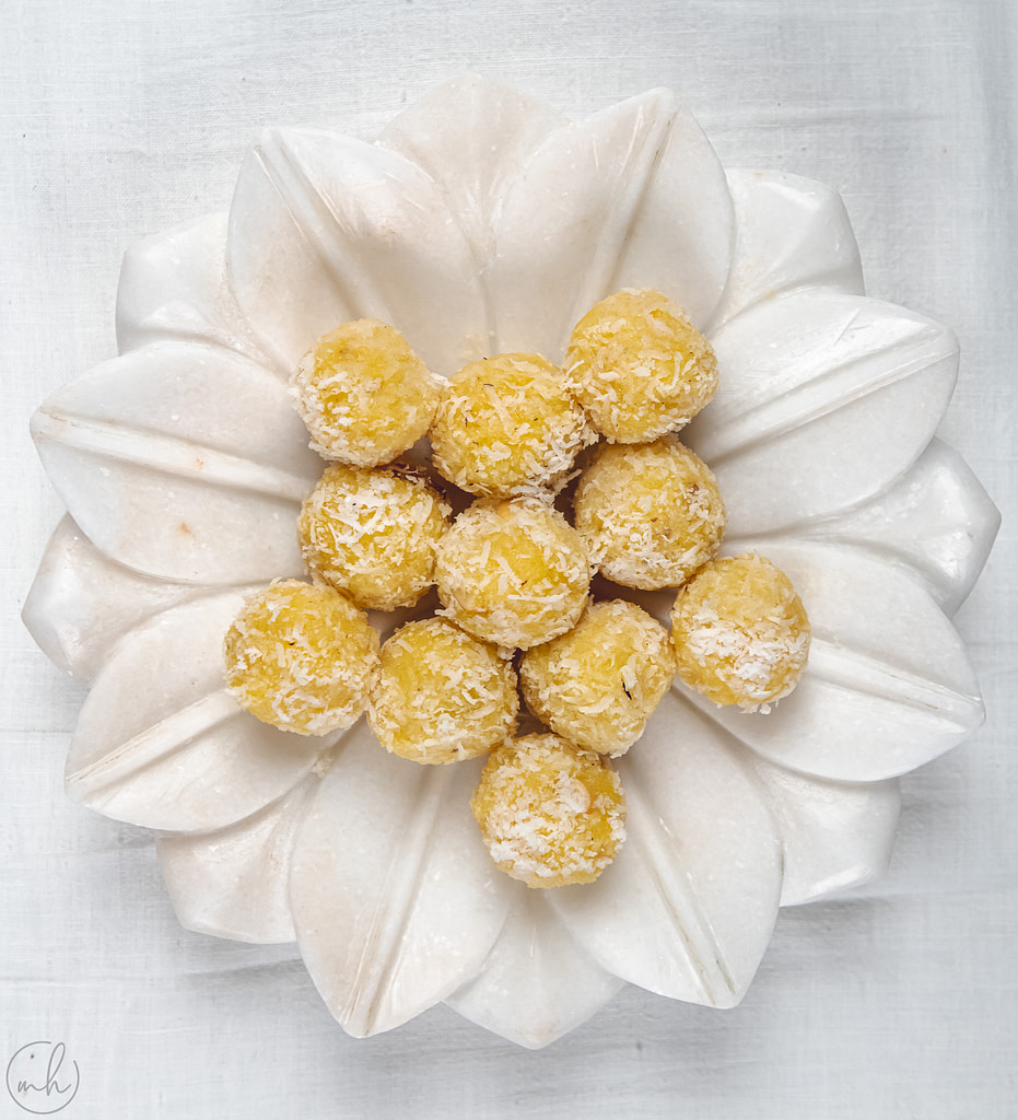 Pineapple coconut energy ball placed on white plate under a white surface
